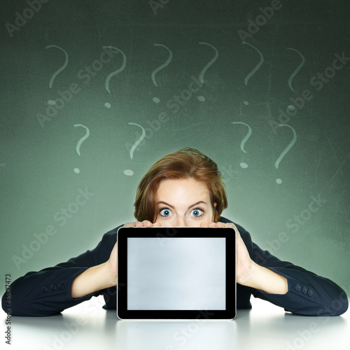 Photo: Businesswoman with doubts showing surprised her tablet computer Businesswoman with doubts showing surprised her tablet computer