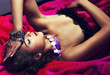 Young gorgeous dreamy woman lying in red dress