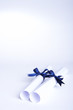 Rolled up certificates tied with blue ribbon