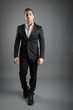 Foto: Young man full body portrait against grey background. Young man full body portrait against grey background.