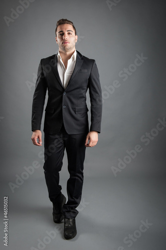 Photo: Young man full body portrait against grey background. Young man full body portrait against grey background.