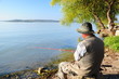 Foto: fisherman is angling, sitting by lake fisherman is angling, sitting by lake