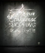 Do your Christmas shopping early, neon sign over old wall.