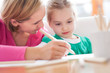 Mother and daughter writing together