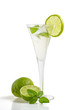 Aperitif mit Limetten und Minze in einer Sektflöte