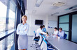 Photo: business woman with her staff in background at office business woman with her staff in background at office