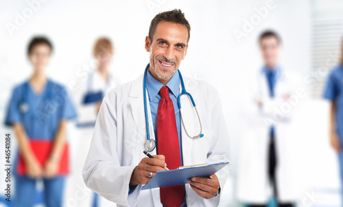 Photo: Smiling doctor in front of his team Smiling doctor in front of his team