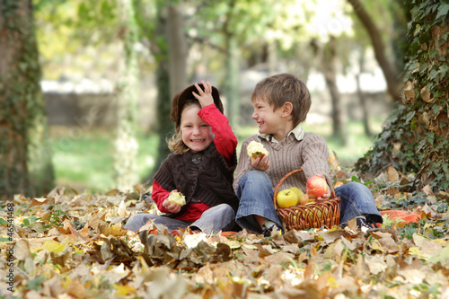 Photo: young happy children - boy and girl - on natural autumn backgrou young happy children - boy and girl - on natural autumn backgrou