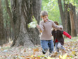 two young happy children - boy and girl - running on natural aut