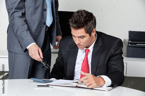 Photo: Two Businessmen Calculating Finances Two Businessmen Calculating Finances