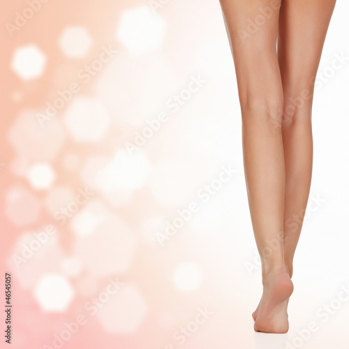 Photo: Long female legs after depilation, abstract blurred background Long female legs after depilation, abstract blurred background