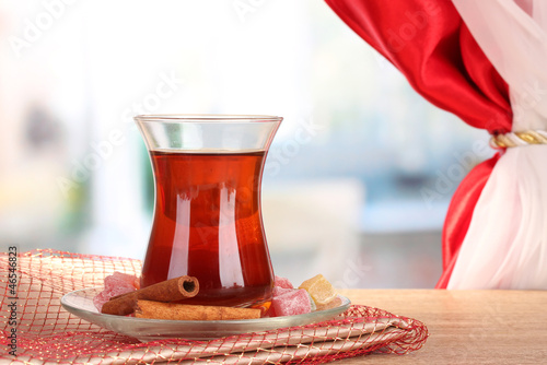 Photo: glass of Turkish tea and rahat lokum, on wooden table glass of Turkish tea and rahat lokum, on wooden table