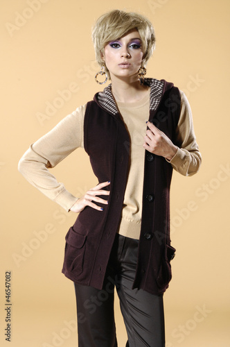 Photo: The fashionable young woman standing on beige background The fashionable young woman standing on beige background