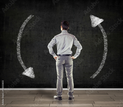 Photo: young business man in front of a blackboard young business man in front of a blackboard