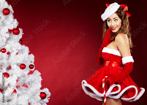 Photo: smiling christmas woman on red background with a christmas-tree smiling christmas woman on red background with a christmas-tree