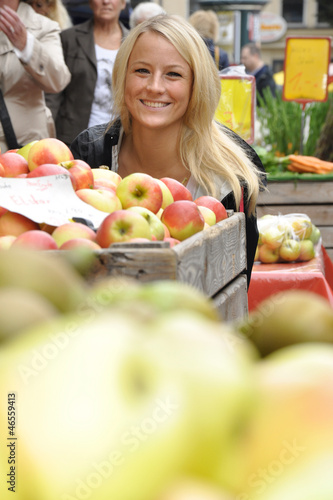 Photo: Junge Frau kauft Äpfel auf Markt Junge Frau kauft Äpfel auf Markt