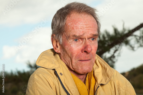 Photo: Senior man with yellow coat. Having cold. Sad looking. Senior man with yellow coat. Having cold. Sad looking.
