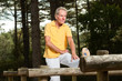 Photo: Senior man stretching his legs. Doing workout in nature. Senior man stretching his legs. Doing workout in nature.