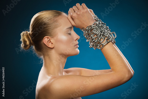 Photo: Closeup of beautiful female model with chained hands Closeup of beautiful female model with chained hands