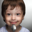 boy with spoon on grey
