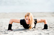 Beautiful fit woman doing push ups on the beach