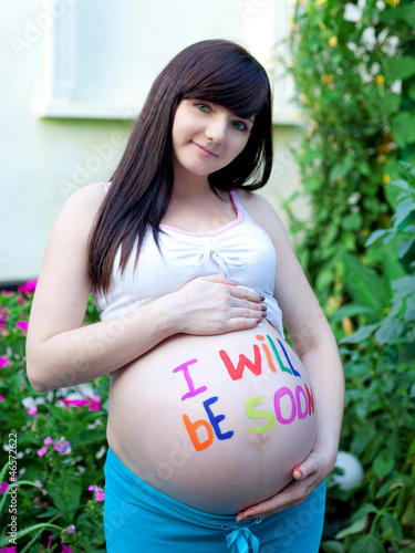 Photo: portrait of pretty young woman expecting a baby,outdoors, portrait of pretty young woman expecting a baby,outdoors,