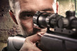 Portrait of serious man aiming with gun