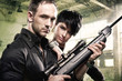 Lovely couple with gun in factory