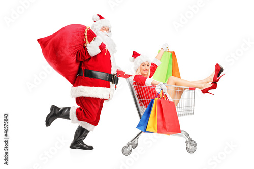 Photo: Santa Claus pushing a woman with shopping bag in a push cart Santa Claus pushing a woman with shopping bag in a push cart