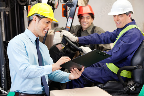 Photo: Male Supervisor Communicating With Forklift Driver And Foreman Male Supervisor Communicating With Forklift Driver And Foreman