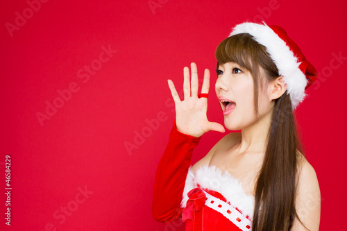 Photo: Beautiful asian woman in santa hat excited for Christmas on red Beautiful asian woman in santa hat excited for Christmas on red