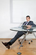 Relaxed Businessman Using Digital Tablet In Office