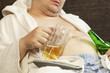 Foto: Drunk man asleep with a beer in the hands of Drunk man asleep with a beer in the hands of