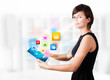 Young woman looking at modern tablet with colourful icons