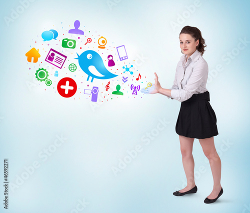 Photo: Young business woman presenting colourful social icons Young business woman presenting colourful social icons