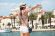 Foto: Happy young woman with outstretched hand and see on old town Happy young woman with outstretched hand and see on old town