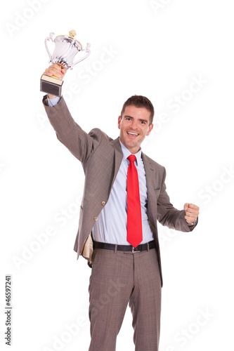 Photo: Business man raising trophy Business man raising trophy