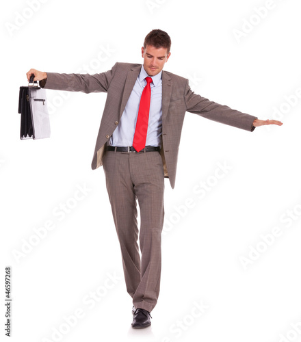 Photo: Business man with briefcase walk on wire Business man with briefcase walk on wire