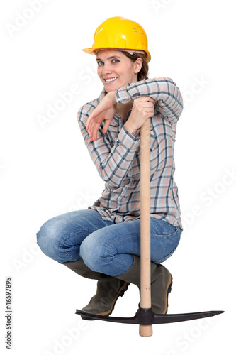 Photo: Woman kneeling by a pickax Woman kneeling by a pickax