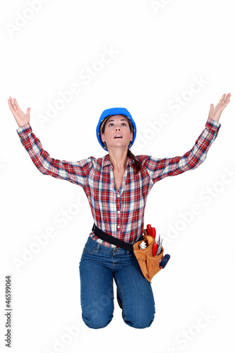 Photo: craftswoman kneeling and raising hands craftswoman kneeling and raising hands