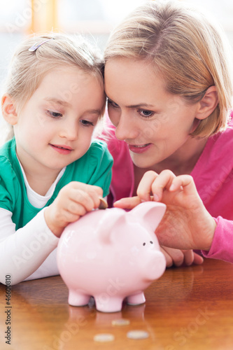 Photo: Mother and daughter with piggy bank Mother and daughter with piggy bank