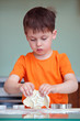 Five year old boy helps his mother make cookies