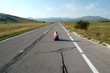 Girl sitting on an empty road