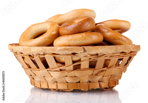 Photo: tasty bagels in basket, isolated on white tasty bagels in basket, isolated on white