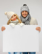 couple in a winter clothes holding blank board