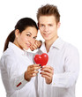 Photo: Couple holding a red heart, isolated on white background Couple holding a red heart, isolated on white background
