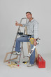 Carpenter stood by ladder giving the thumbs-up