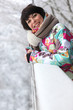 Woman leaning against a snow-covered ledge