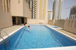 man swim in swimming pool at roof of apartment, bahrain