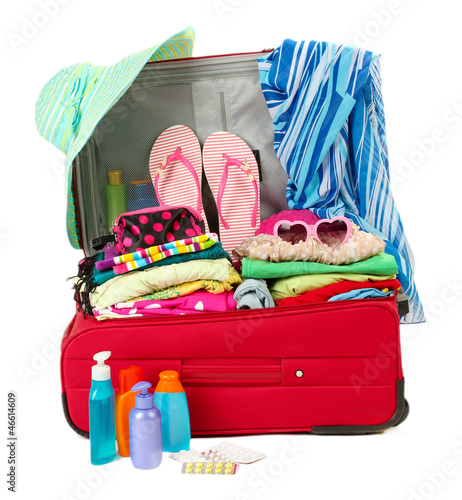 Photo: Red travel suitcase with personal belongings isolated on white Red travel suitcase with personal belongings isolated on white